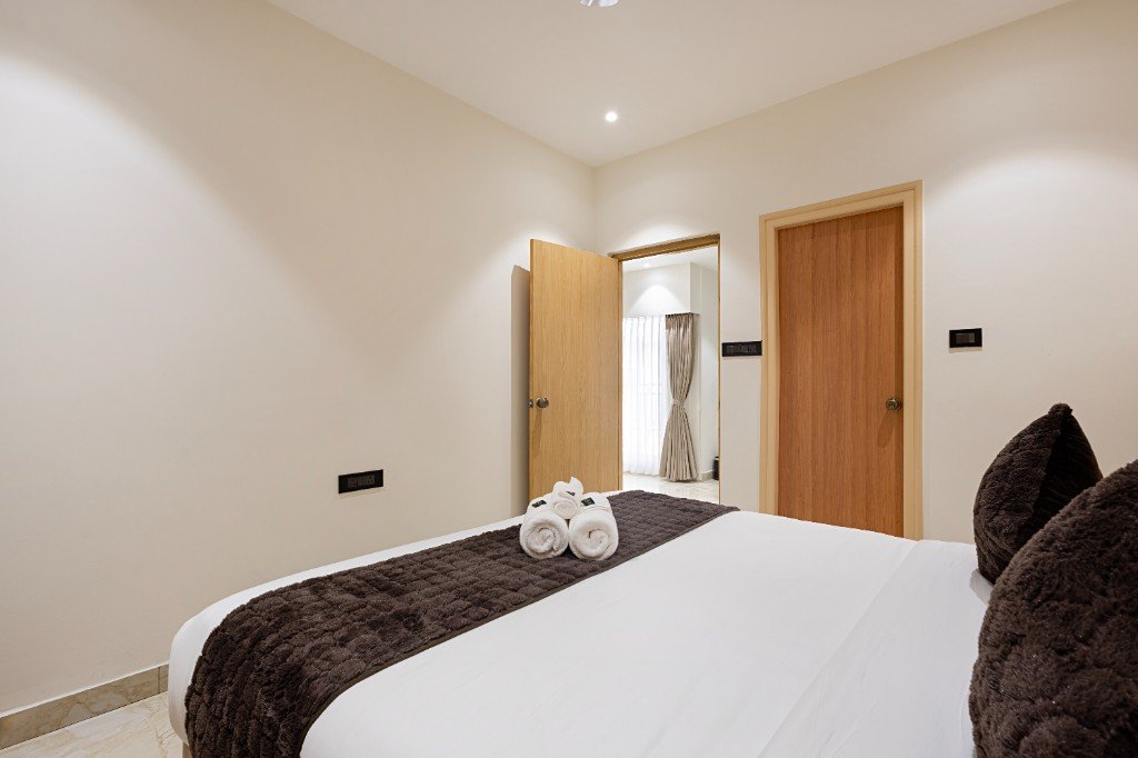 Elysium Premier Suites, Hitec City — Bedroom with headboard lighting